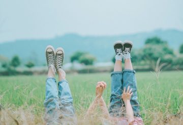 friends with feet in the air holding hands