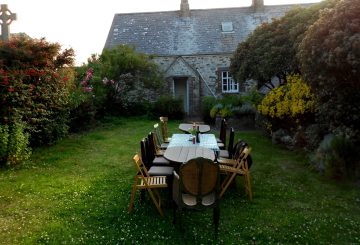 quaint tables on grass in front of brick cottage