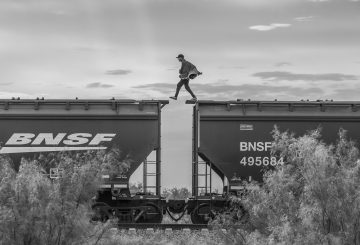 man walking on top of moving train