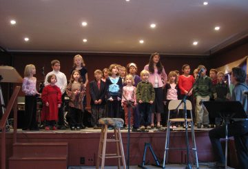 SCC Kids practice singing on stage