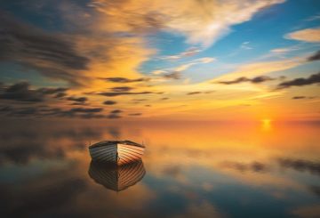 a boat at sunset on serene waters