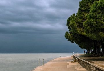 A paved boardwalk with stormy skies but light coming